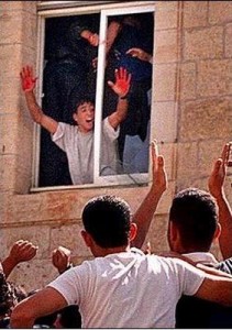 A Ramallah civilian holds up hands stained in the blood of two IDF reservists who took a wrong turn